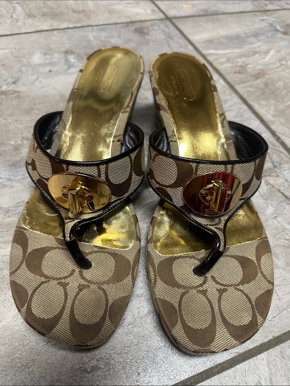 Coach Noble monogrammed platform wedge sandals featuring a metallic gold finish